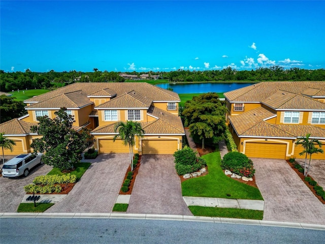 318 Winding Brook Ln Unit 104, Bradenton, FL 34212 - view of front of property featuring a tile roof, driveway, stucco siding, a water view, and an attached garage