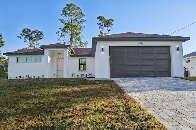 5386 Easter Ter, North Port, FL 34286 - view of front of house with stucco siding, decorative driveway, a front yard, and a garage