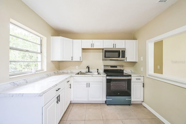 314 W Owens Ave, Arcadia, FL 34266 - kitchen featuring stainless steel appliances, white cabinets, light countertops, and light tile patterned floors