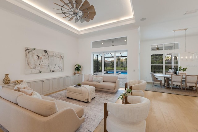 16511 Cornwall Ln, Lakewood Ranch, FL 34202 - living area featuring healthy amount of natural light, light wood-style flooring, a tray ceiling, and a high ceiling