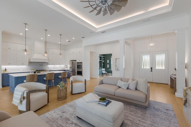 16511 Cornwall Ln, Lakewood Ranch, FL 34202 - living area featuring decorative columns, light wood-style flooring, crown molding, a tray ceiling, and recessed lighting