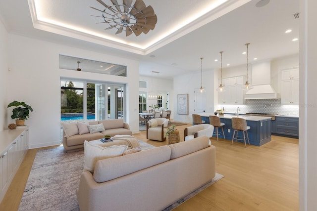 16511 Cornwall Ln, Lakewood Ranch, FL 34202 - living room featuring light wood finished floors, recessed lighting, and a tray ceiling
