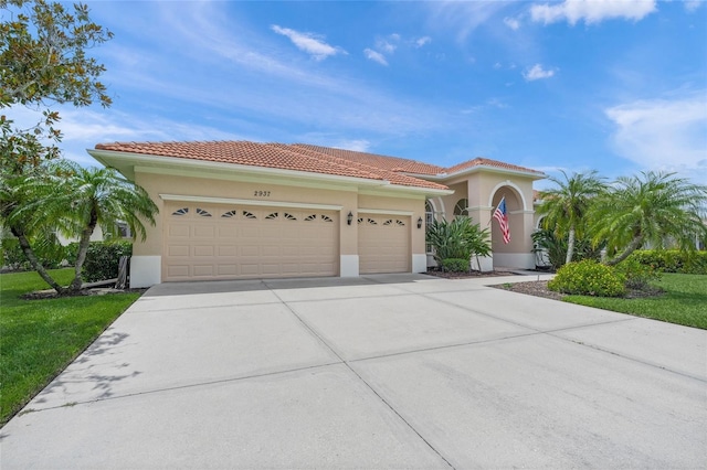 2937 Seasons Blvd, Sarasota, FL 34240 - mediterranean / spanish house with an attached garage, concrete driveway, stucco siding, and a tile roof