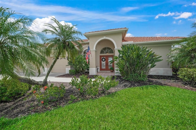 2937 Seasons Blvd, Sarasota, FL 34240 - view of front of home with a garage, stucco siding, a front lawn, a tile roof, and french doors