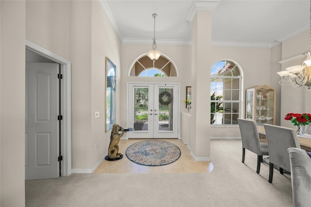 2937 Seasons Blvd, Sarasota, FL 34240 - tiled foyer entrance with a chandelier, carpet, crown molding, french doors, and a towering ceiling