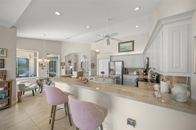 2937 Seasons Blvd, Sarasota, FL 34240 - kitchen featuring stainless steel appliances, ceiling fan, arched walkways, decorative backsplash, and a peninsula