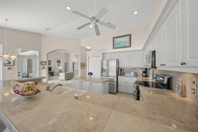 2937 Seasons Blvd, Sarasota, FL 34240 - kitchen with appliances with stainless steel finishes, a ceiling fan, arched walkways, tasteful backsplash, and white cabinets