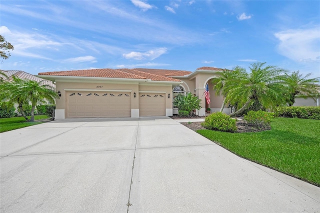 2937 Seasons Blvd, Sarasota, FL 34240 - mediterranean / spanish house with an attached garage, concrete driveway, a front lawn, stucco siding, and a tile roof