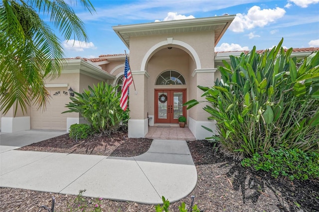 2937 Seasons Blvd, Sarasota, FL 34240 - view of exterior entry with french doors, stucco siding, a garage, and concrete driveway