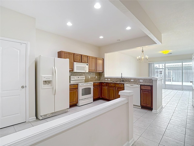 26548 Castleview Way, Wesley Chapel, FL 33544 - kitchen with white appliances, a peninsula, light tile patterned flooring, brown cabinetry, and a chandelier