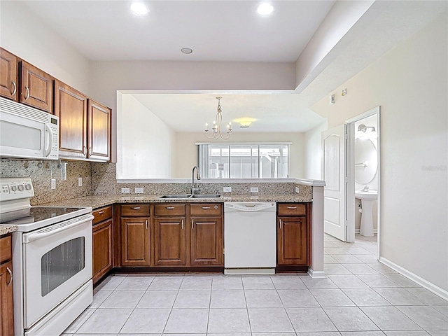 26548 Castleview Way, Wesley Chapel, FL 33544 - kitchen with white appliances, a peninsula, a chandelier, backsplash, and light tile patterned flooring