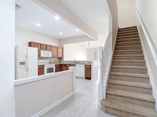 26548 Castleview Way, Wesley Chapel, FL 33544 - kitchen with white appliances, a peninsula, light tile patterned flooring, a chandelier, and decorative backsplash