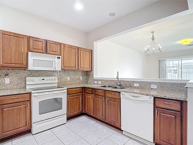 26548 Castleview Way, Wesley Chapel, FL 33544 - kitchen featuring white appliances, brown cabinetry, and a peninsula