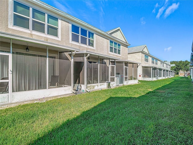 26548 Castleview Way, Wesley Chapel, FL 33544 - rear view of house with a sunroom, a lawn, and stucco siding