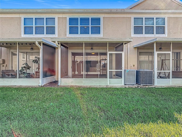 26548 Castleview Way, Wesley Chapel, FL 33544 - back of property featuring a sunroom, a yard, and stucco siding