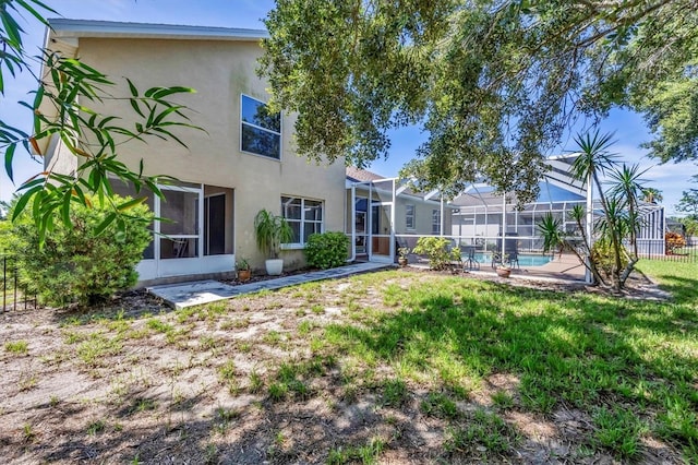 815 Greenview Dr, Apollo Beach, FL 33572 - rear view of house featuring stucco siding and glass enclosure