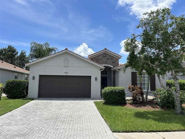 4407 67th St E, Bradenton, FL 34203 - ranch-style house featuring stucco siding, a garage, decorative driveway, stone siding, and a front lawn