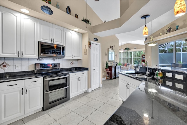 2801 SW 29th Ct, Cape Coral, FL 33914 - kitchen with appliances with stainless steel finishes, backsplash, decorative light fixtures, light tile patterned flooring, and dark stone counters