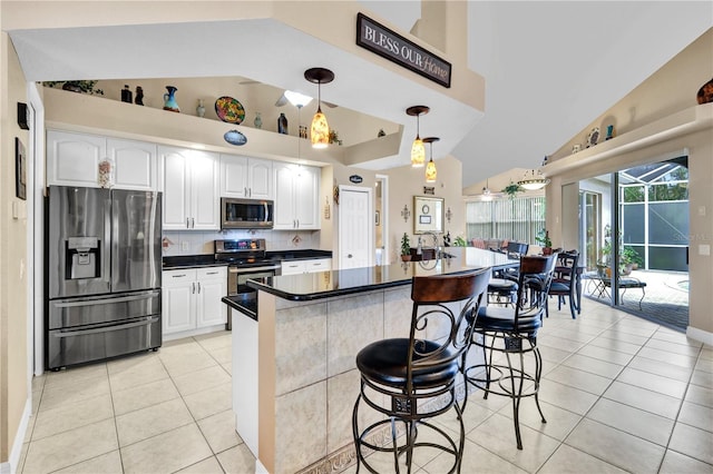 2801 SW 29th Ct, Cape Coral, FL 33914 - kitchen featuring appliances with stainless steel finishes, high vaulted ceiling, light tile patterned floors, tasteful backsplash, and white cabinets