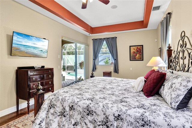 2801 SW 29th Ct, Cape Coral, FL 33914 - bedroom with access to outside, wood finished floors, a tray ceiling, and a ceiling fan