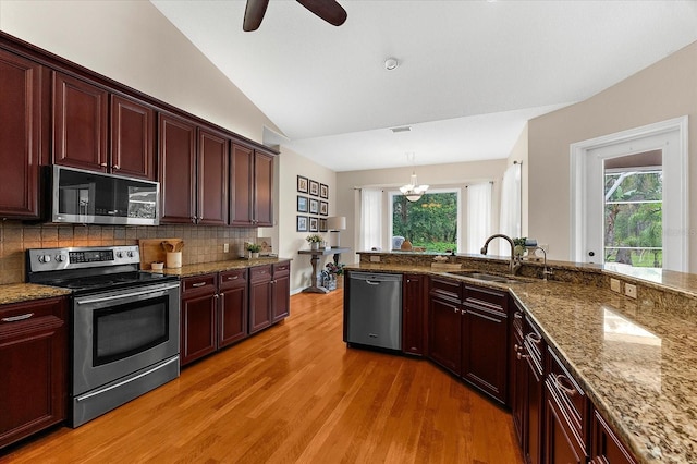21705 67th Ave E, Bradenton, FL 34211 - kitchen with stainless steel appliances, light wood finished floors, tasteful backsplash, lofted ceiling, and healthy amount of natural light