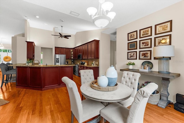 21705 67th Ave E, Bradenton, FL 34211 - dining area with light wood-style floors, ceiling fan, a chandelier, and vaulted ceiling