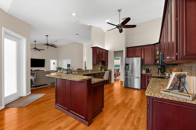 21705 67th Ave E, Bradenton, FL 34211 - kitchen featuring stainless steel fridge, a ceiling fan, a peninsula, reddish brown cabinets, and high vaulted ceiling