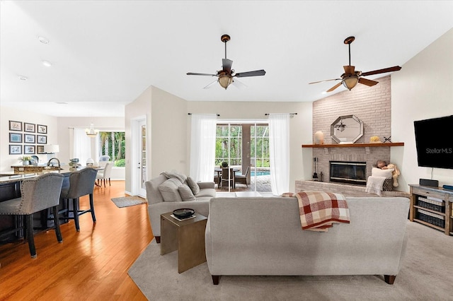 21705 67th Ave E, Bradenton, FL 34211 - living area featuring a ceiling fan, a fireplace, and light wood finished floors
