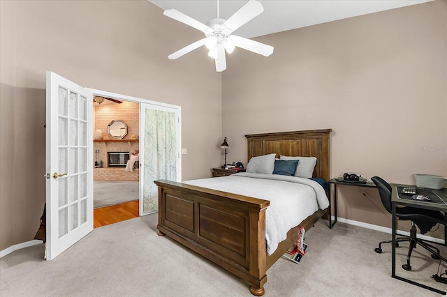 21705 67th Ave E, Bradenton, FL 34211 - bedroom featuring light carpet, an office area, a towering ceiling, a brick fireplace, and ceiling fan