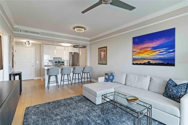 750 N Tamiami Trl Unit 1005, Sarasota, FL 34236 - living area with crown molding, light wood-style flooring, and ceiling fan