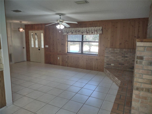 8851 S Brittany Path, Inverness, FL 34452 - unfurnished living room featuring wood walls, ceiling fan, a textured ceiling, and a chandelier