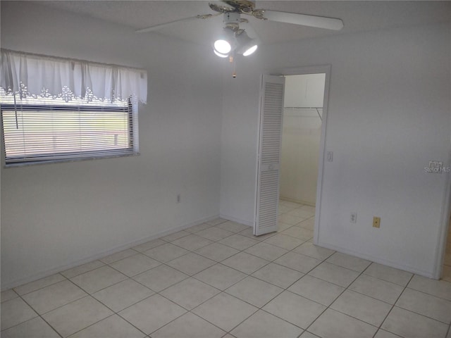 8851 S Brittany Path, Inverness, FL 34452 - unfurnished bedroom featuring a closet, light tile patterned floors, a spacious closet, and a ceiling fan