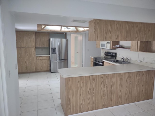 8851 S Brittany Path, Inverness, FL 34452 - kitchen with appliances with stainless steel finishes, light countertops, a peninsula, light tile patterned floors, and brown cabinetry