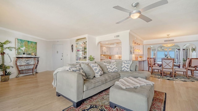 1 Benjamin Franklin Dr Unit 93, Sarasota, FL 34236 - living area with arched walkways, light wood-style floors, crown molding, and ceiling fan