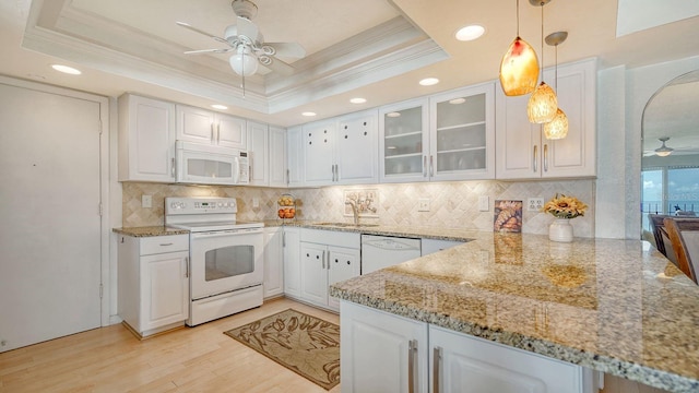1 Benjamin Franklin Dr Unit 93, Sarasota, FL 34236 - kitchen featuring white appliances, ceiling fan, a tray ceiling, crown molding, and tasteful backsplash
