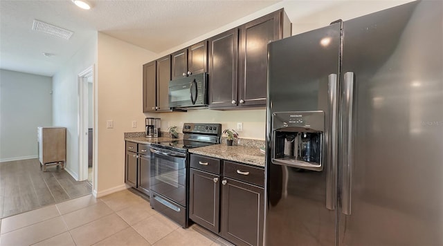 3813 Willow Branch Pl, Palmetto, FL 34221 - kitchen with black appliances, dark brown cabinetry, stone counters, and light tile patterned floors