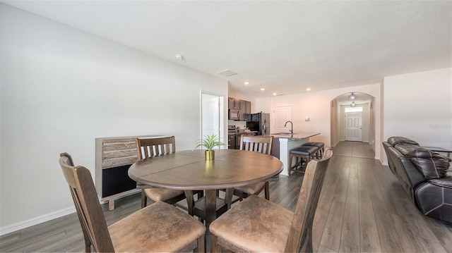 3813 Willow Branch Pl, Palmetto, FL 34221 - dining space featuring arched walkways, wood finished floors, and recessed lighting