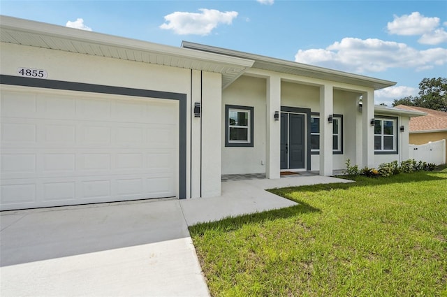 4855 Dragon St, North Port, FL 34288 - view of front of home with stucco siding, a front lawn, concrete driveway, and an attached garage