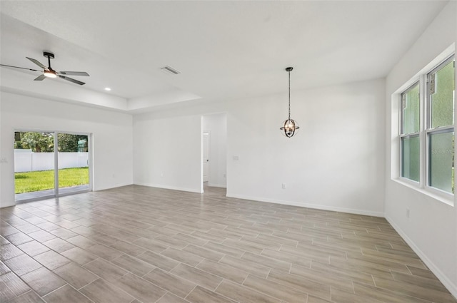 4855 Dragon St, North Port, FL 34288 - empty room with healthy amount of natural light, a ceiling fan, a tray ceiling, light wood-type flooring, and recessed lighting