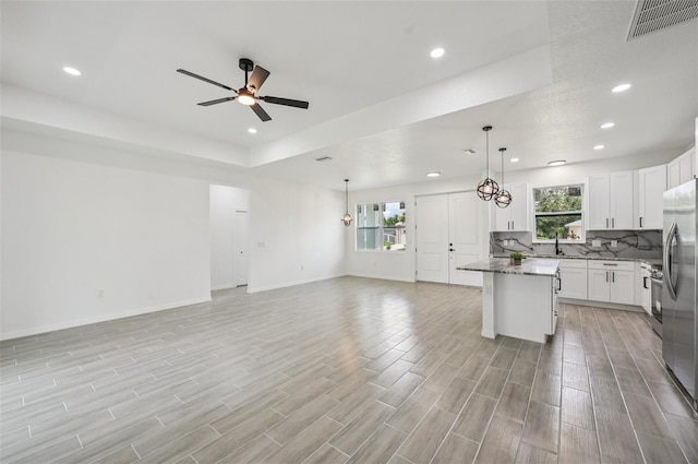 4855 Dragon St, North Port, FL 34288 - kitchen featuring open floor plan, a ceiling fan, recessed lighting, backsplash, and light wood-style flooring