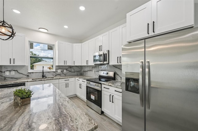 4855 Dragon St, North Port, FL 34288 - kitchen with stainless steel appliances, white cabinetry, light stone counters, decorative backsplash, and recessed lighting