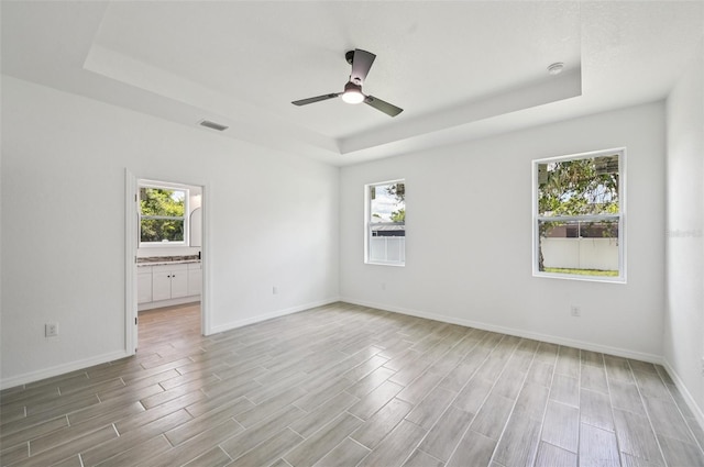 4855 Dragon St, North Port, FL 34288 - spare room with a tray ceiling, healthy amount of natural light, and light wood-type flooring