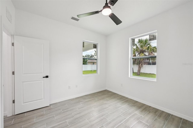 4855 Dragon St, North Port, FL 34288 - empty room with plenty of natural light, a ceiling fan, and light wood-style floors