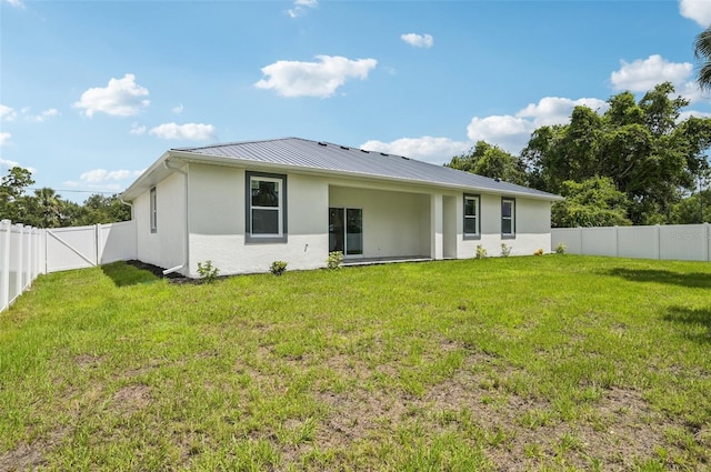 4855 Dragon St, North Port, FL 34288 - back of house with stucco siding, a fenced backyard, a metal roof, and a standing seam roof