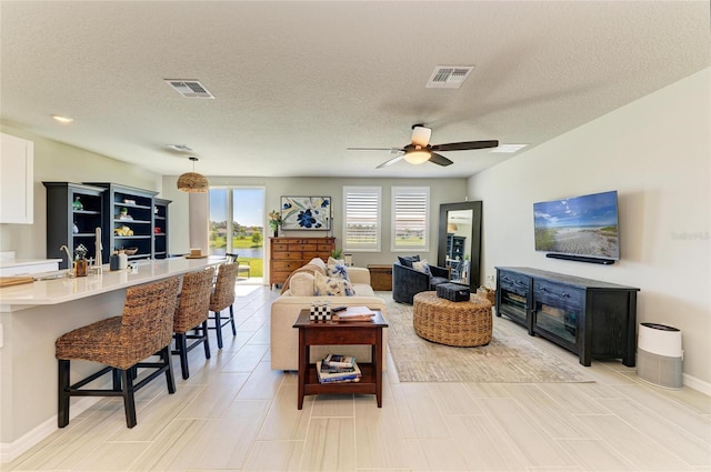 7160 Amelia River Dr, Parrish, FL 34219 - living room featuring ceiling fan and a textured ceiling