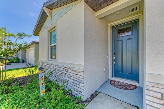 7160 Amelia River Dr, Parrish, FL 34219 - doorway to property with stucco siding, stone siding, and an attached garage