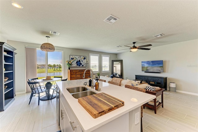 7160 Amelia River Dr, Parrish, FL 34219 - kitchen with light countertops, white cabinetry, a ceiling fan, a textured ceiling, and hanging light fixtures