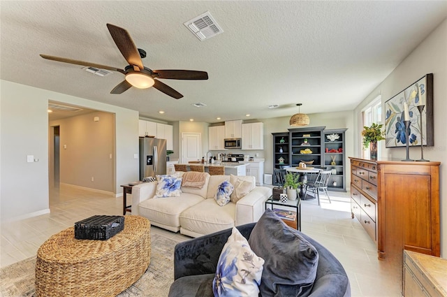 7160 Amelia River Dr, Parrish, FL 34219 - living room with a ceiling fan, a textured ceiling, and light tile patterned floors