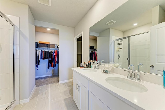 7160 Amelia River Dr, Parrish, FL 34219 - bathroom with a walk in closet, double vanity, a stall shower, and recessed lighting