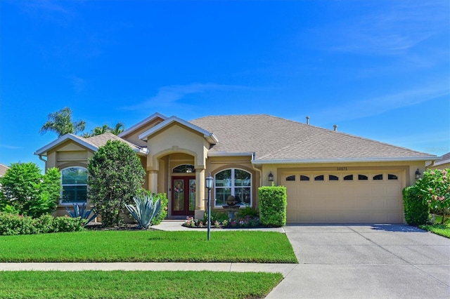 10571 Old Grove Cir, Bradenton, FL 34212 - ranch-style home featuring an attached garage, concrete driveway, stucco siding, a front yard, and a shingled roof